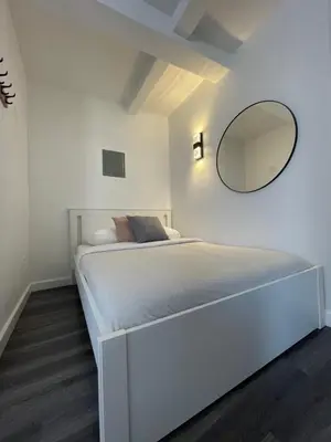 a bedroom with a bed with a mirror on the wall at Hotel and the City, Rooftop City View in New York