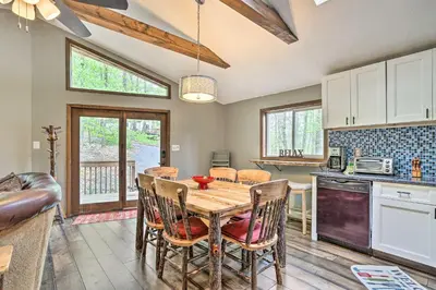 a kitchen and dining room with a table and chairs at Walk to Lake and Beach Pocono Cabin with Fire Pit in Pocono Lake