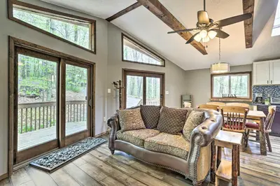 a living room with a couch and a table at Walk to Lake and Beach Pocono Cabin with Fire Pit in Pocono Lake