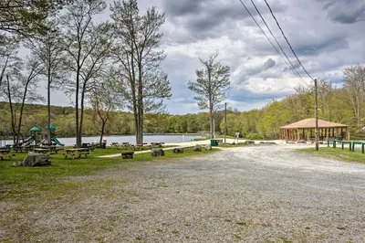 a park with benches and a gazebo next to a lake at Walk to Lake and Beach Pocono Cabin with Fire Pit in Pocono Lake