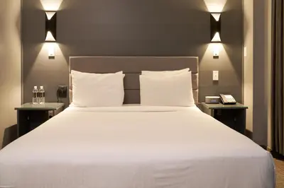 a bedroom with a large white bed with two tables at Lex Hotel NYC in New York