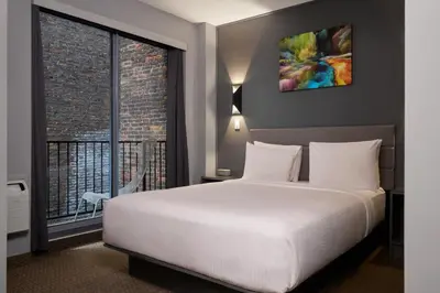 a bedroom with a white bed and a large window at Lex Hotel NYC in New York