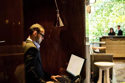 a man in a suit working on a laptop computer at Hotel Hugo in New York