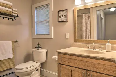 a bathroom with a toilet and a sink and a mirror at Large Yard and Games Edgewater Escape in Paupack! in Paupack