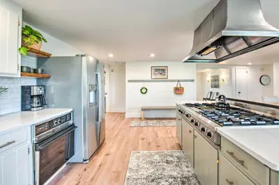 a kitchen with stainless steel appliances and wooden floors at 3 Mi to Dutch Wonderland Serene Home with Deck in Lancaster