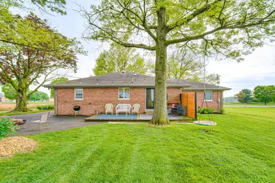 a brick house with a patio and a yard at 3 Mi to Dutch Wonderland Serene Home with Deck in Lancaster