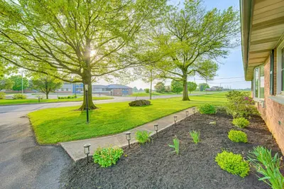 a yard with trees and plants next to a building at 3 Mi to Dutch Wonderland Serene Home with Deck in Lancaster