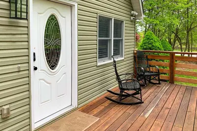 a porch with a white door and a rocking chair at Near Lakes and Resorts Pet-Friendly Long Pond Abode in Long Pond