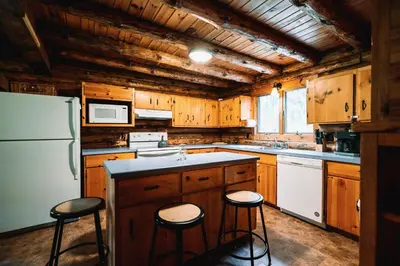 a kitchen with wooden cabinets and a white refrigerator at Afton Cabin in Afton