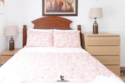 a bedroom with a bed with two night stands and two lamps at Beautifully Designed & Spacious Apartment in Newark 10mins from EWR Airport, Close to NYC and Beth Israel Hospital in Newark