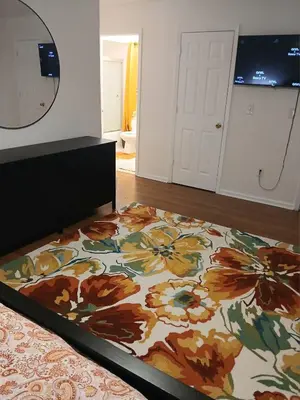 a bedroom with a bed with a flower rug at Beautifully Designed & Spacious Apartment in Newark 10mins from EWR Airport, Close to NYC and Beth Israel Hospital in Newark
