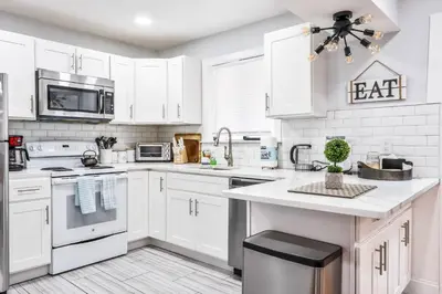a white kitchen with white cabinets and appliances at Beautiful Mount Pocono Chalet with Hot Tub!! in Tobyhanna