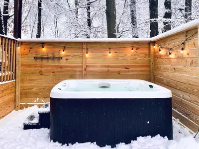 a jacuzzi tub in the snow with lights at Beautiful Mount Pocono Chalet with Hot Tub!! in Tobyhanna