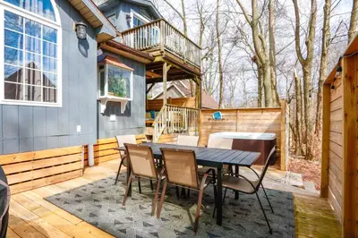 a patio with a table and chairs on a deck at Beautiful Mount Pocono Chalet with Hot Tub!! in Tobyhanna