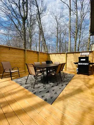 a patio with a table and chairs and a piano at Beautiful Mount Pocono Chalet with Hot Tub!! in Tobyhanna