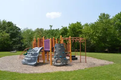 a playground in a park with two slides at Beautiful Mount Pocono Chalet with Hot Tub!! in Tobyhanna