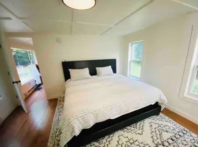 a bedroom with a large bed and a rug at The Cabin @ Benton Hollow in Livingston Manor