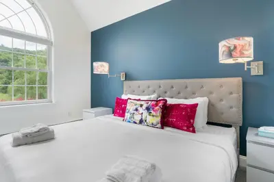 a bedroom with a large white bed with red pillows at Malkita Aria Mountainview Retreat in Woodbury
