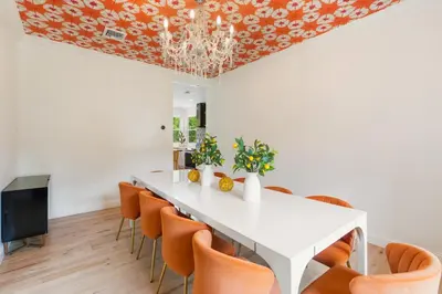 a dining room with a white table and orange chairs at Malkita Aria Mountainview Retreat in Woodbury