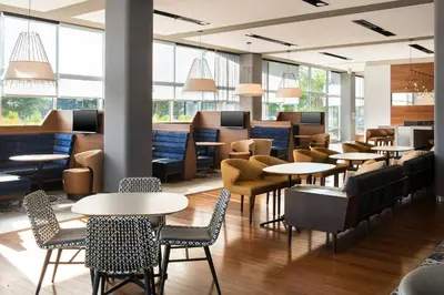 a restaurant with tables and chairs and windows at Courtyard by Marriott Philadelphia South at The Navy Yard in Philadelphia