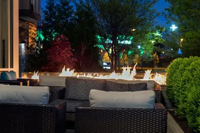 a group of wicker chairs sitting on a patio at night at Courtyard by Marriott Philadelphia South at The Navy Yard in Philadelphia