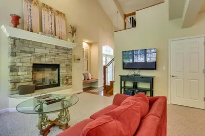 a living room with a red couch and a fireplace at Half-Mi to Big Boulder Lake Townhome with Deck! in Lake Harmony