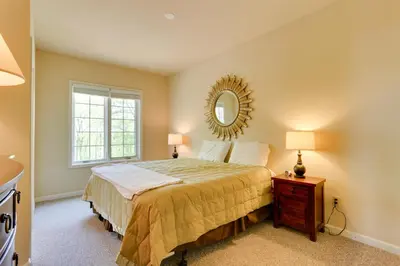 a bedroom with a bed and a mirror on the wall at Half-Mi to Big Boulder Lake Townhome with Deck! in Lake Harmony