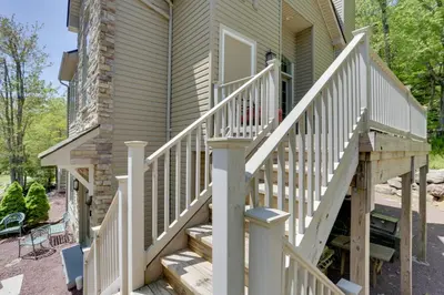 a house with a wooden staircase leading up to the front door at Half-Mi to Big Boulder Lake Townhome with Deck! in Lake Harmony