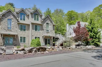 a large house with rocks in front of it at Half-Mi to Big Boulder Lake Townhome with Deck! in Lake Harmony