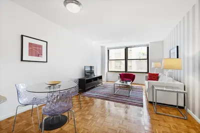a living room with a table and chairs and a couch at Furnished Quarters at Grove Pointe in Jersey City