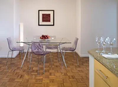 a dining room with a glass table and purple chairs at Furnished Quarters at Grove Pointe in Jersey City