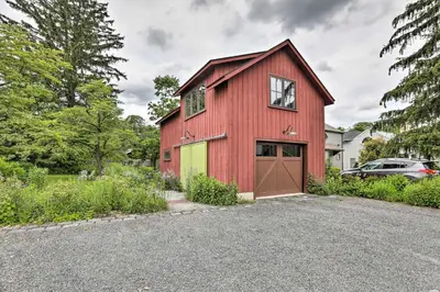 a red barn with a garage at Barn-Like Studio Suite with Flowering Garden! in Titusville