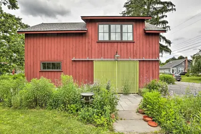 a red house with a green door and a garden at Barn-Like Studio Suite with Flowering Garden! in Titusville