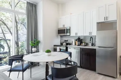 a kitchen with a table and chairs and a refrigerator at Sosuite at French Quarters - Rittenhouse Square in Philadelphia