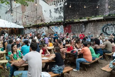 a crowd of people sitting at tables in front of a wall at Sosuite at French Quarters - Rittenhouse Square in Philadelphia