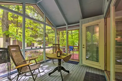 a screened in porch with a table and chairs on it at Deck and Resort Amenities Pocono Lake Home in Pocono Lake