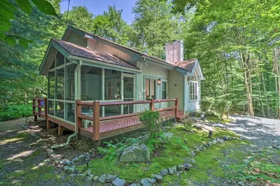 a small green house with a large porch at Deck and Resort Amenities Pocono Lake Home in Pocono Lake