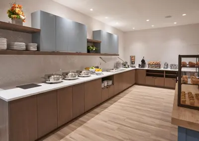 a large kitchen with wooden cabinets and white counter tops at Staybridge Suites Wilmington Downtown by IHG in Wilmington