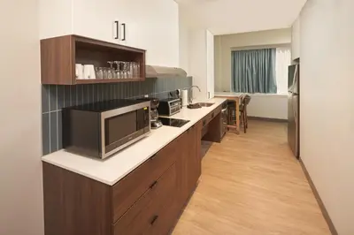 a kitchen with a long counter with a tv on it at Staybridge Suites Wilmington Downtown by IHG in Wilmington