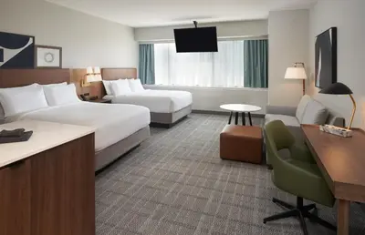 a hotel room with two beds and a desk at Staybridge Suites Wilmington Downtown by IHG in Wilmington