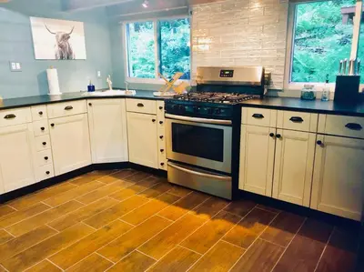 a kitchen with white cabinets and a stove at Bear Cottage in Birchwood Lakes