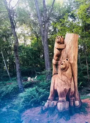 a statue of two bears on a tree stump at Bear Cottage in Birchwood Lakes