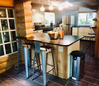 a kitchen with a island with bar stools at Bear Cottage in Birchwood Lakes