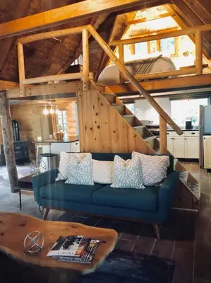 a living room with a blue couch and a staircase at Bear Cottage in Birchwood Lakes