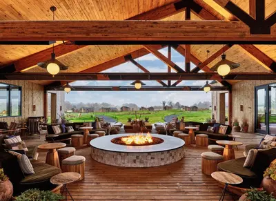 a lobby with a fire pit and chairs and tables at Wildflower Farms, Auberge Collection in Gardiner