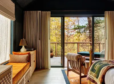 a bedroom with a bed and a sliding glass door at Wildflower Farms, Auberge Collection in Gardiner