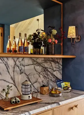 a counter with bottles of wine on a wall at Wildflower Farms, Auberge Collection in Gardiner
