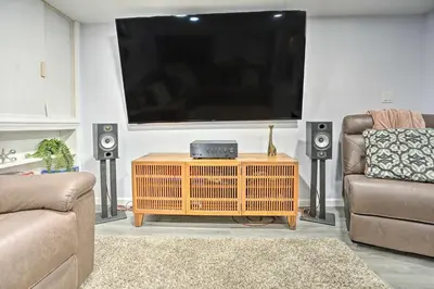 a living room with a flat screen tv and speakers at Saddle Brook Studio with Patio - Near NYC! in Saddle Brook