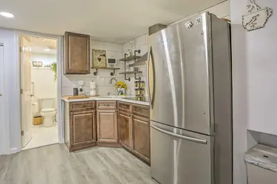 a kitchen with a stainless steel refrigerator and wooden cabinets at Saddle Brook Studio with Patio - Near NYC! in Saddle Brook