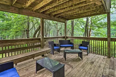 a screened porch with chairs and tables on it at 7 Mi to Lake Harmony Home with Furnished Deck! in Albrightsville